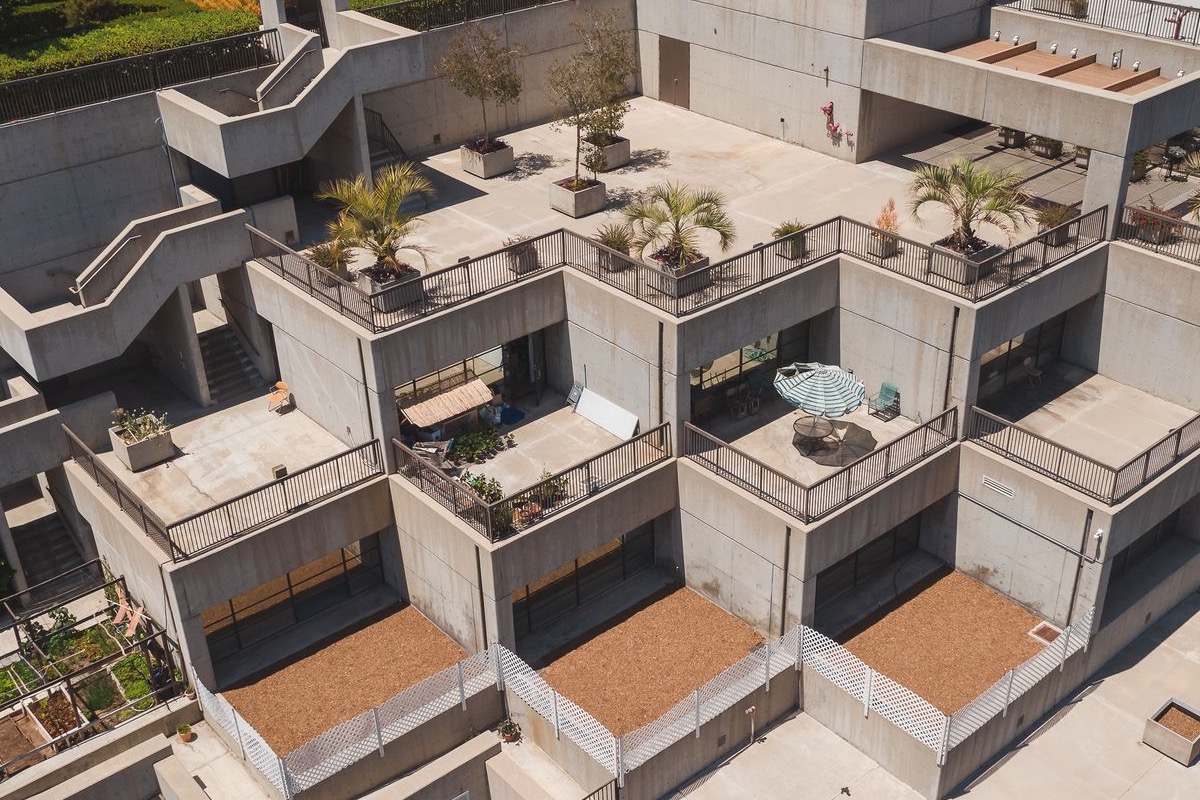 Aerial of a modern building's concrete roof terraces and decks with planters