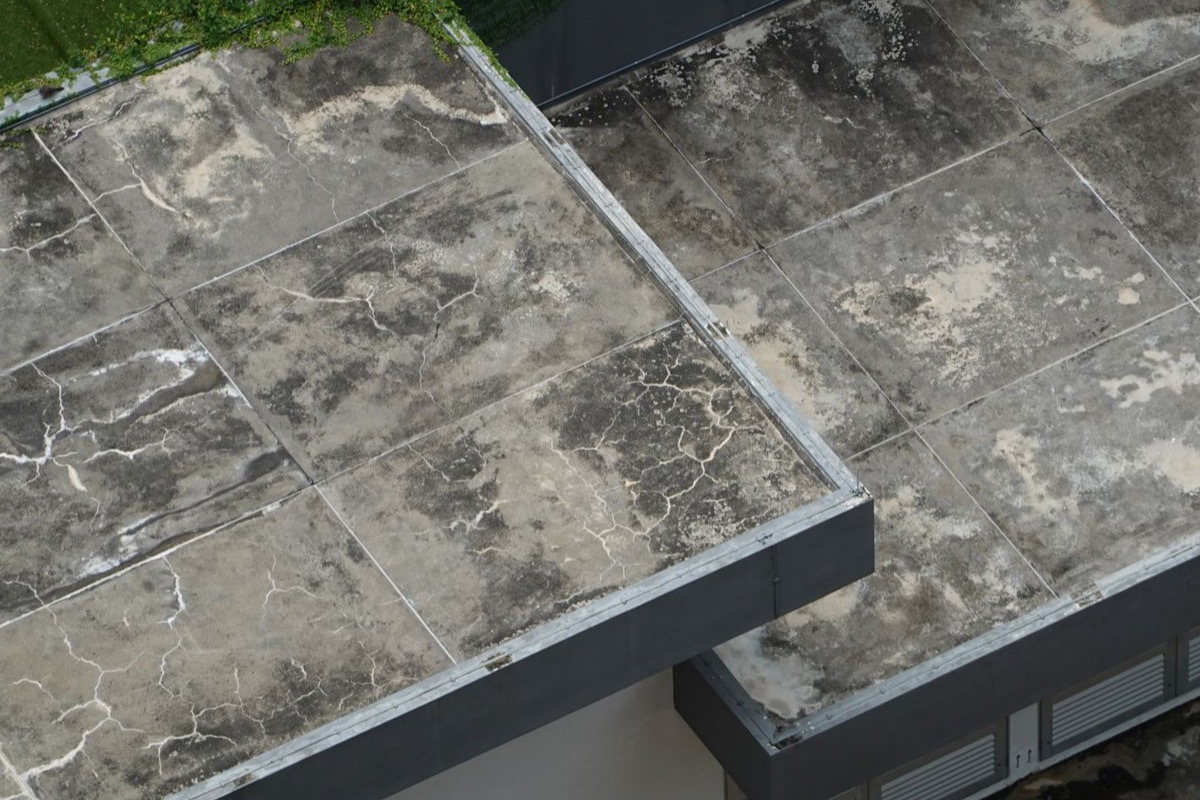 Aerial view of a weathered reinforced-concrete flat roof deck with parapets